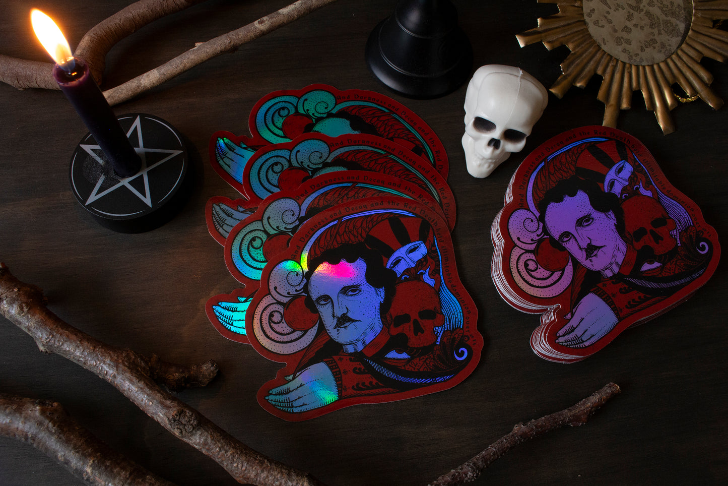 Glowing stickers with artistic designs on a dark surface with candles and branches.