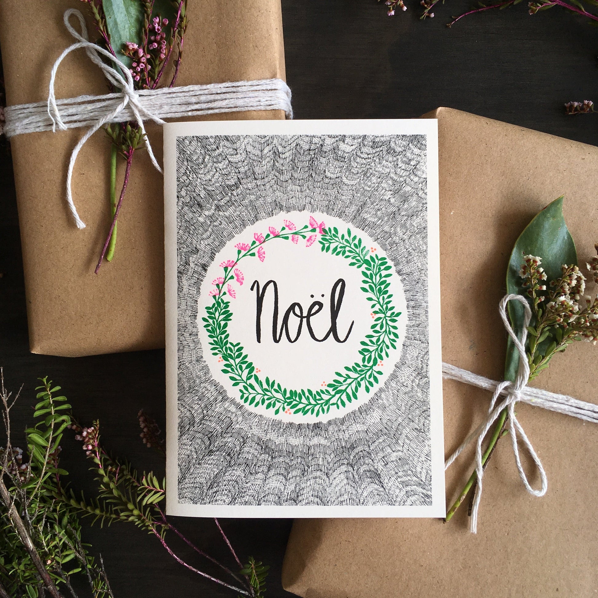 Greeting card with Noel written at the center surrounded by a wreath